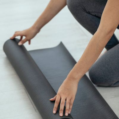 A yoga mat rolled out on a wooden floor, ready for practice.